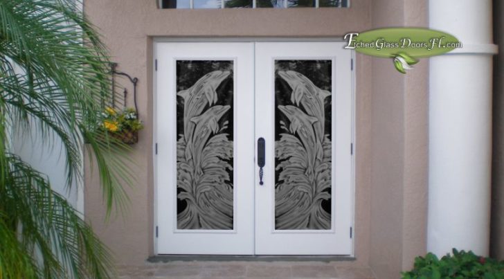Dolphins etched on double doors with waves